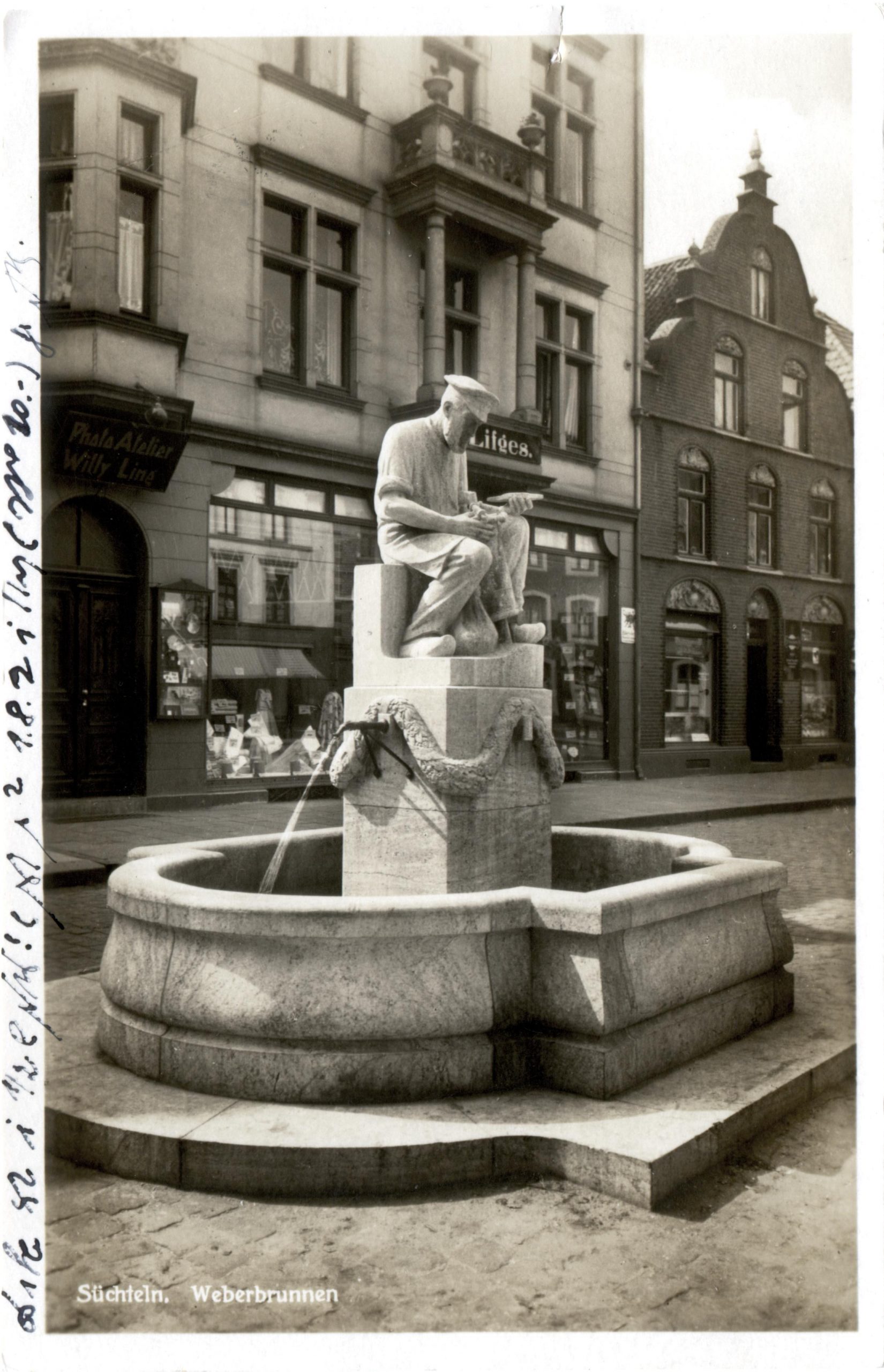 Weberbrunnen in Süchteln um 1921. Im Hintergrund befand sich das Ladenlokal der Familie Lifges. In dem Gebäude findet man heute ein Geschäft der Kette „ernstings family“.; Quelle: Kreisarchiv